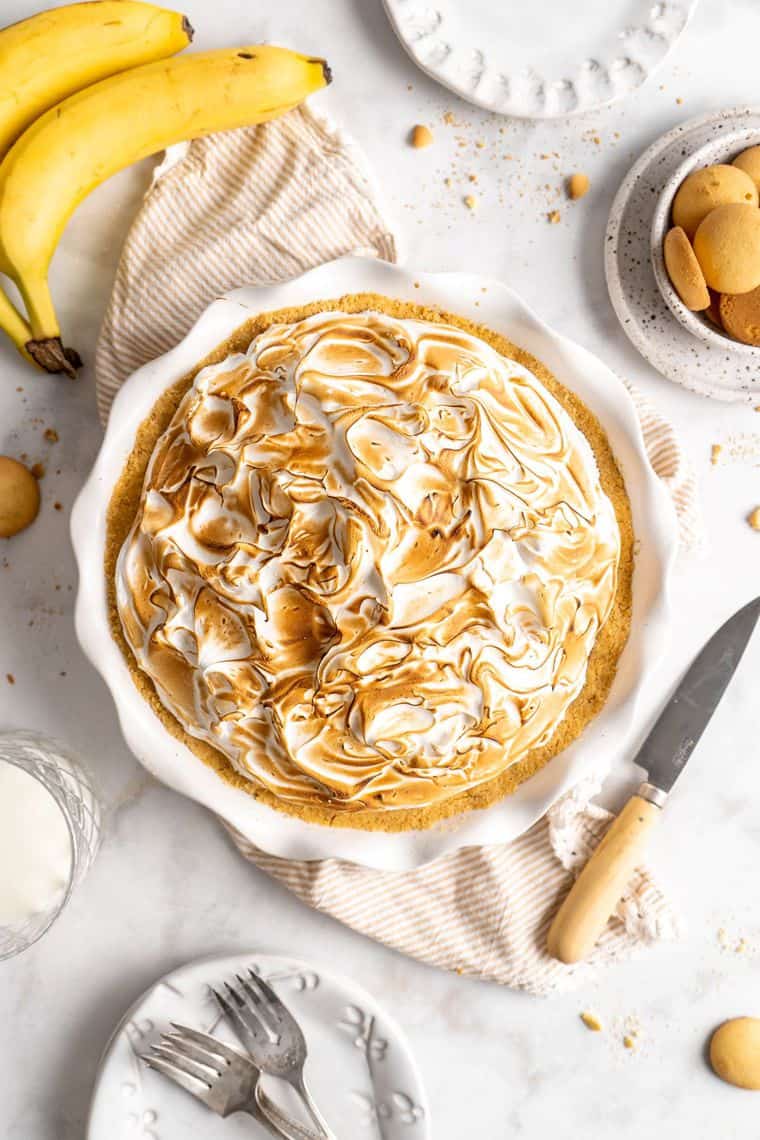 An overhead of a banana pudding pie with meringue topping against a white background