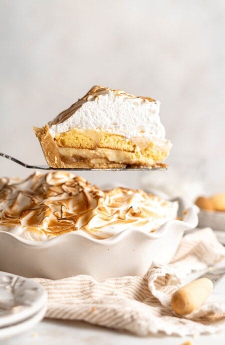 A slice of banana pudding pie being taken from center of pie