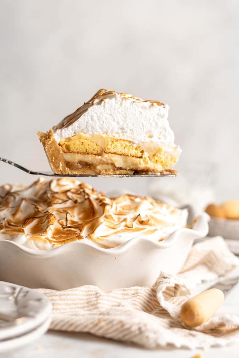 A slice of banana pudding pie being taken from center of pie