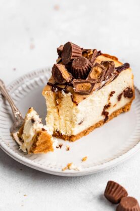 A slice of cheesecake cut into with chocolate chips and peanut butter