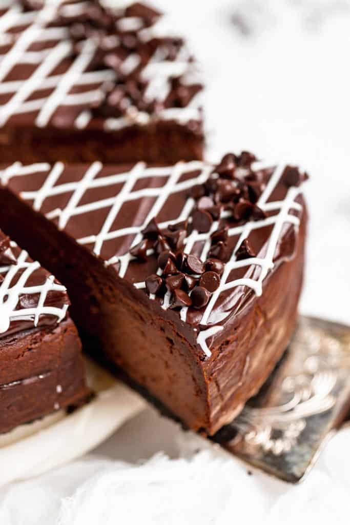 A close up of a slice of chocolate cheesecake about to be served