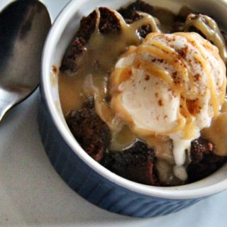 sticky pudding made with gingerbread cake in a blue ramekin ready to eat with ice cream on top