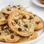 A plate of homemade Mrs Field's chocolate chip cookies on a plate.