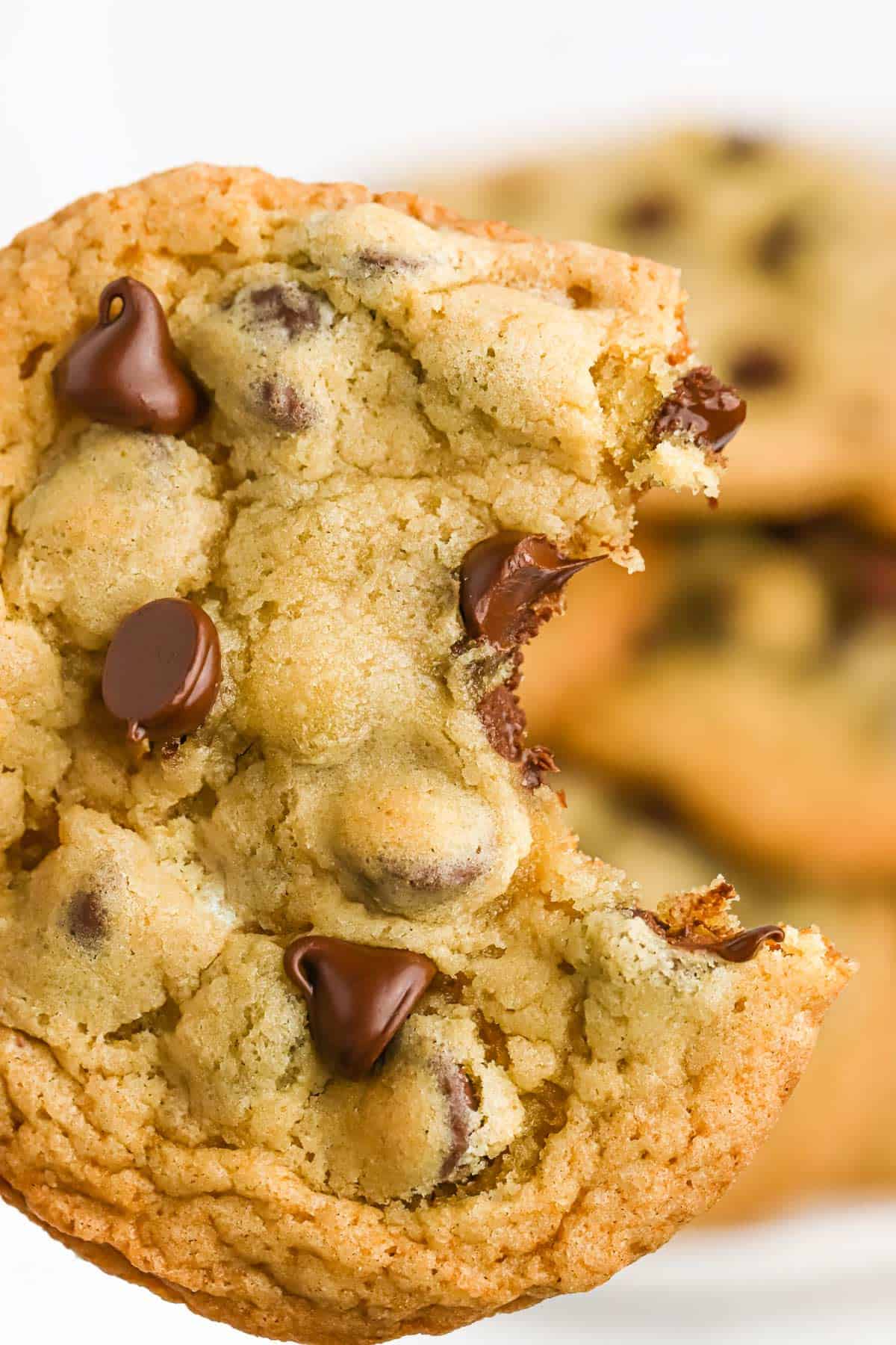 A closeup of a chocolate chip cookie with a bite missing!