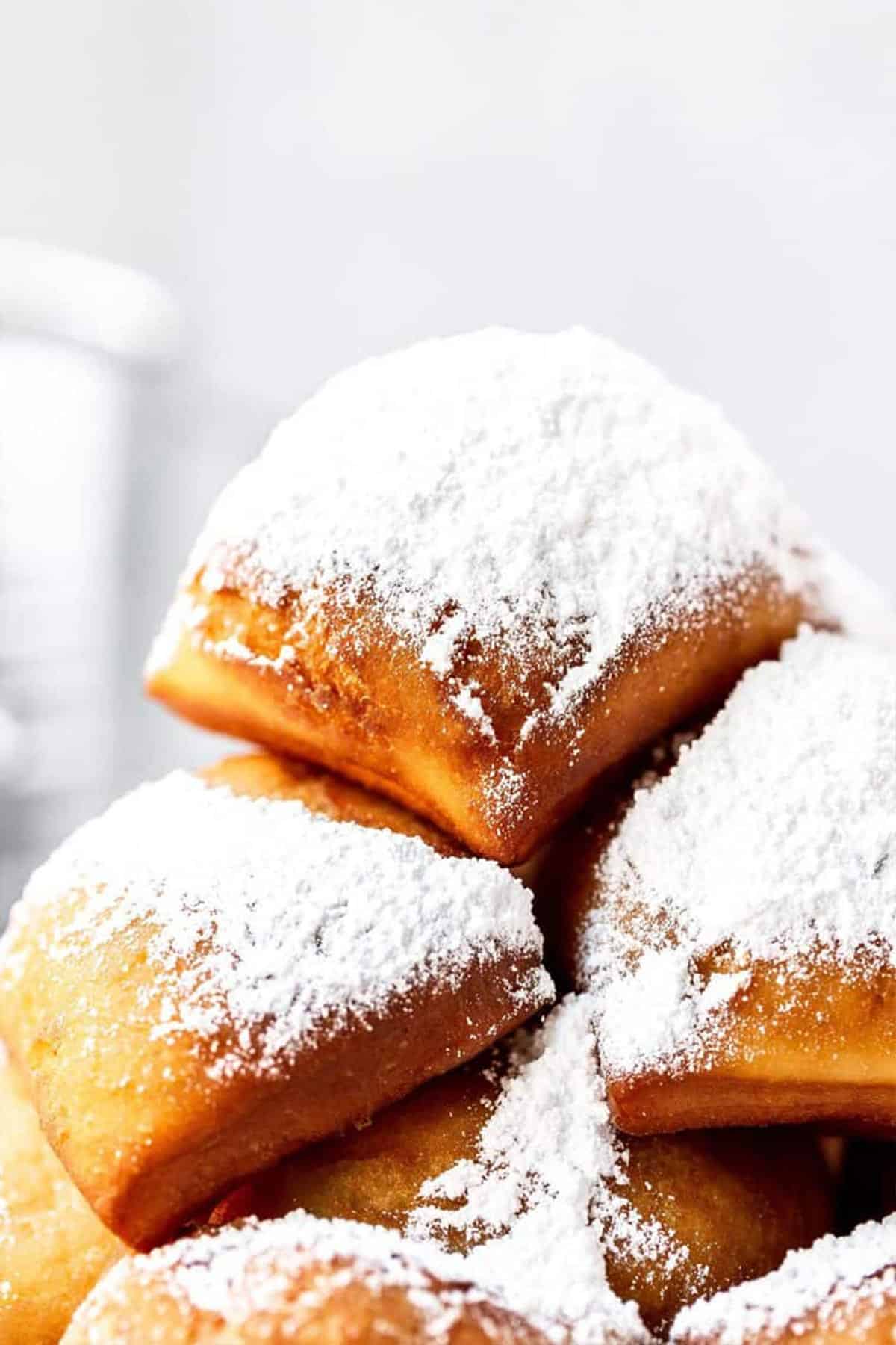 Extreme close up of two New Orleans beignets stacked in a pile.