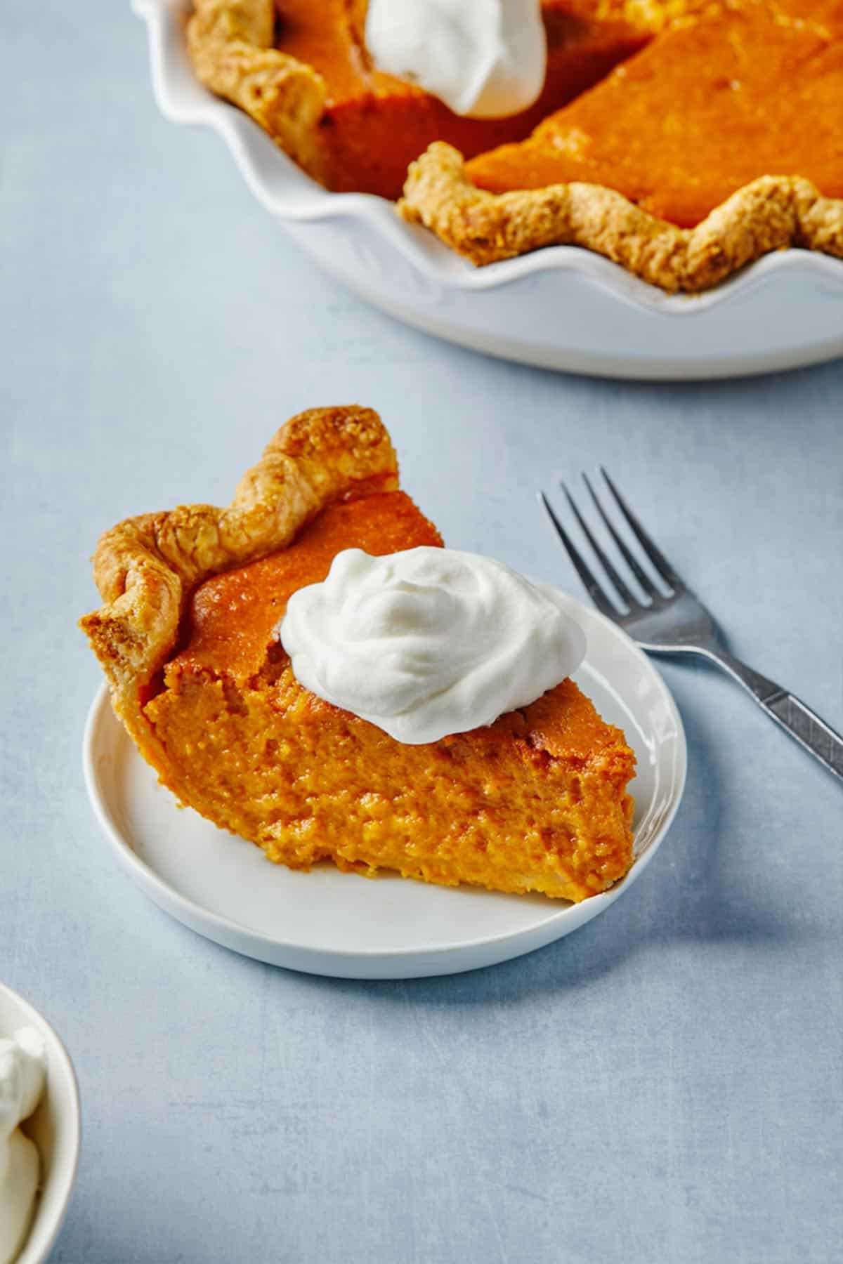 A slice of Black folks sweet potato pie on a white plate ready to serve