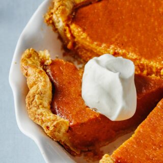 Sweet Potato Pie Recipe with a slice that has whipped cream still in the pie container