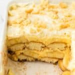 Banana pudding tiramisu in a baking dish with a serving missing.