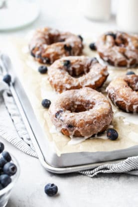 Tray of Blueberry Glazed Doughnuts on parchment paper