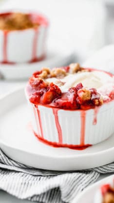 Individual strawberry crumble with melted ice cream on top