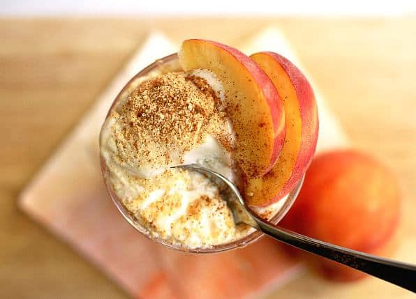 Overhead shot of an Easy Peach Pie Ice Cream Float contained in a tall, clear glass and topped with peach slices.
