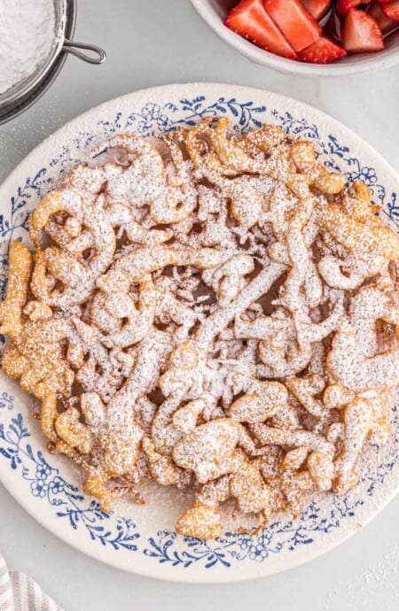 A stack of funnel cakes with powdered sugar on top