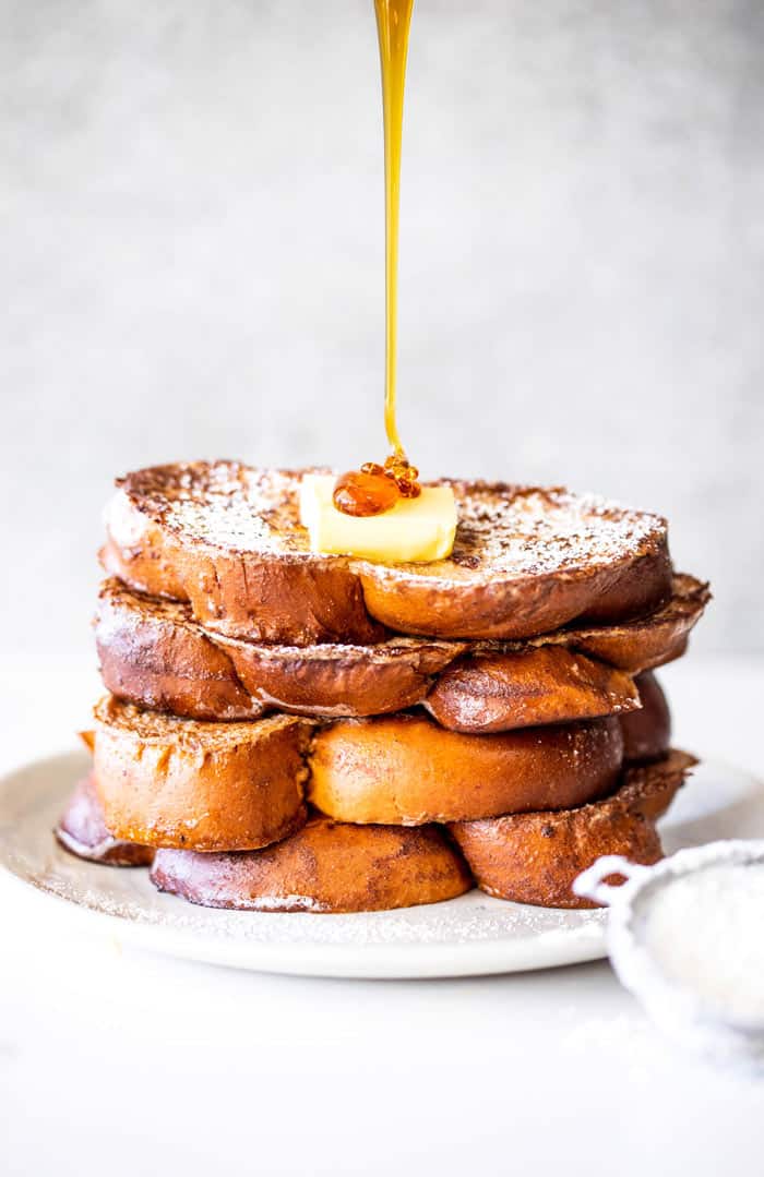 Syrup being poured over a stack of eggnog french toast