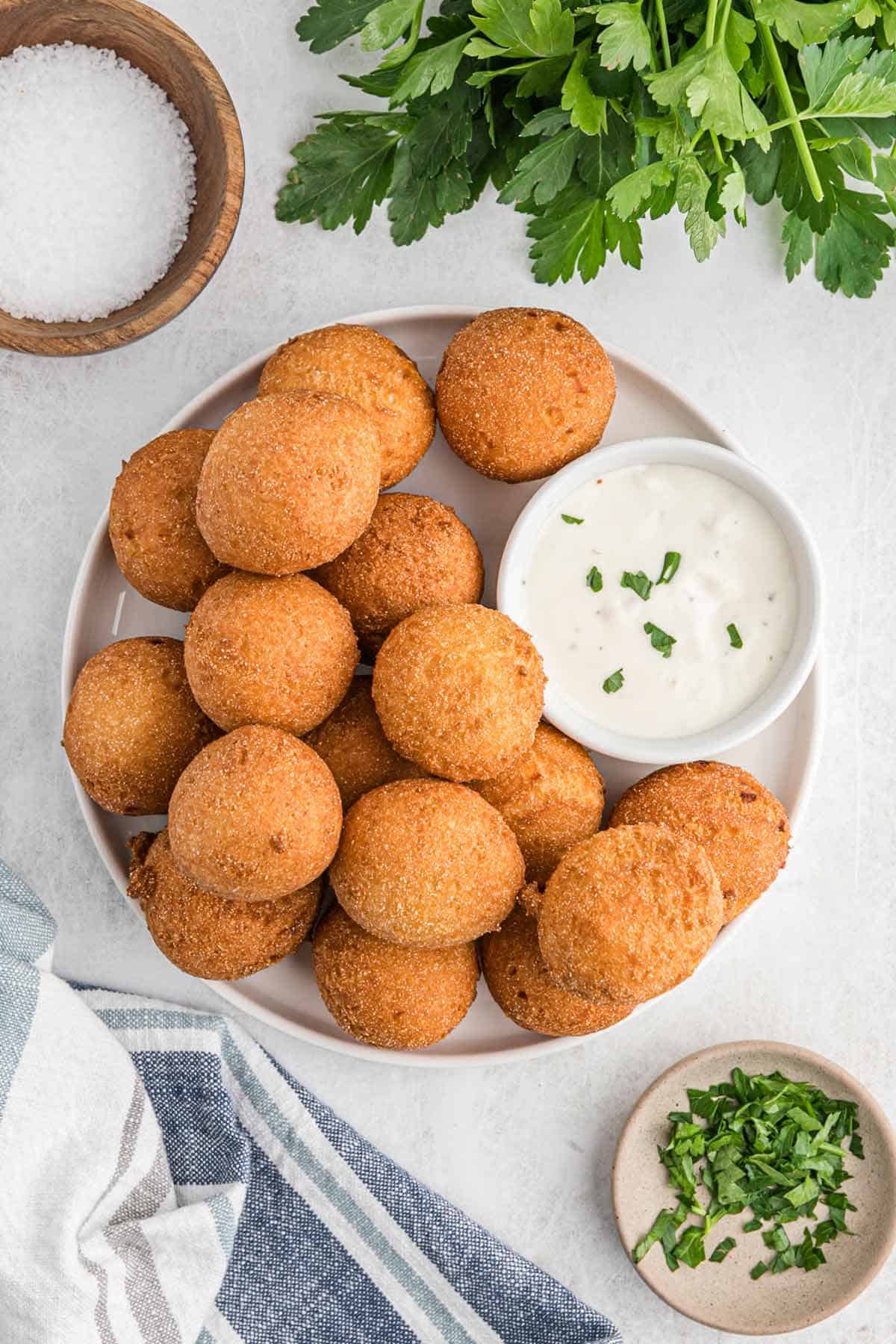 Fried hush puppies spilling out of bowl