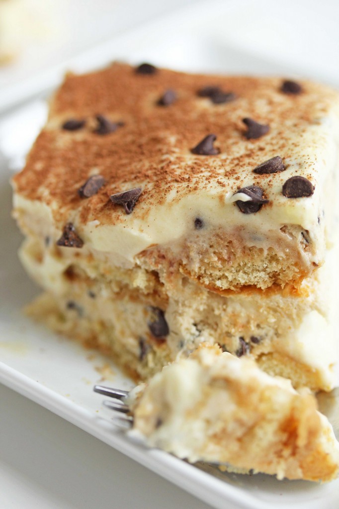 Close up of a piece of cookie dough tiramisu in a square, white plate with a fork