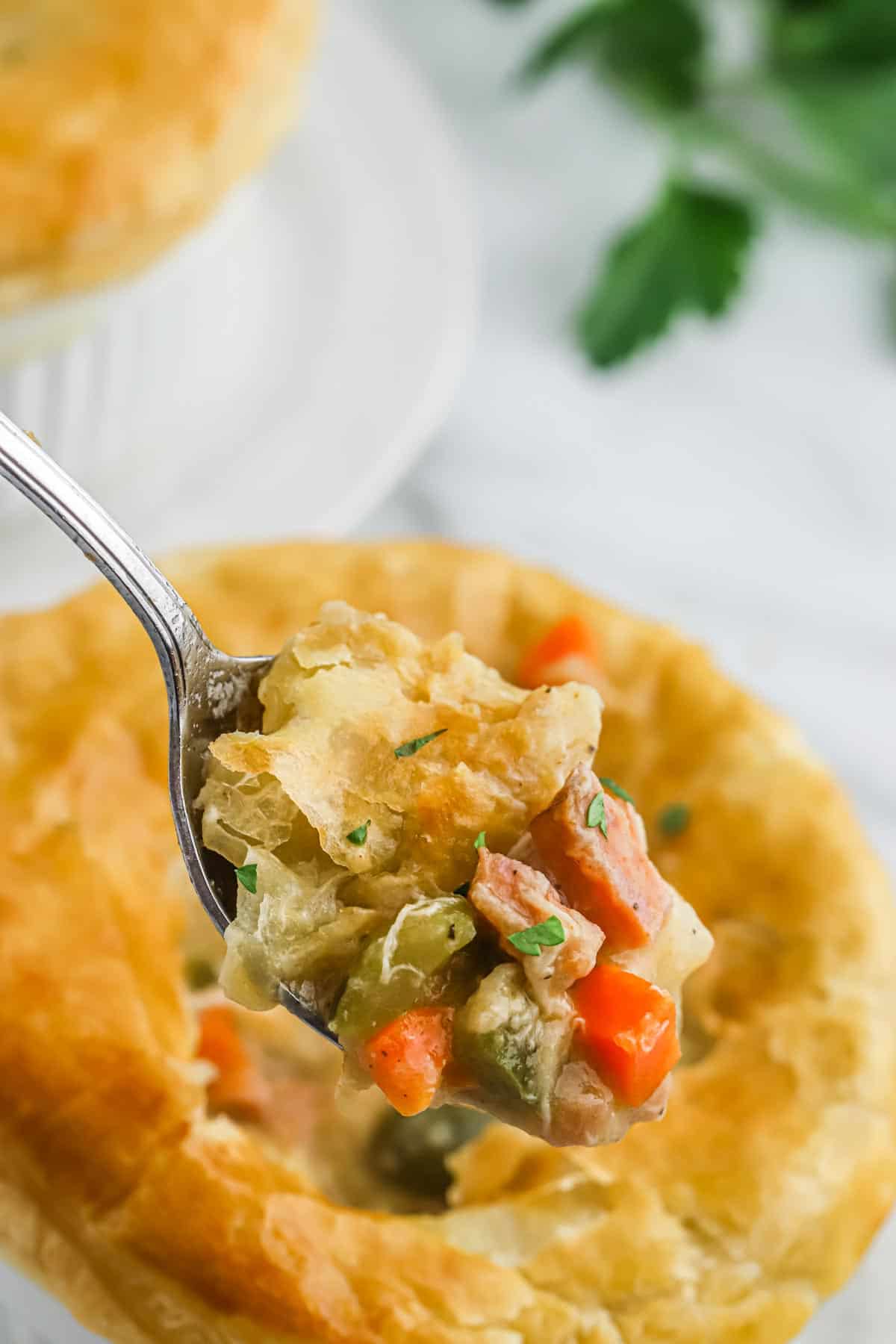 A spoonful of sausage pot pie up over the baked pot pie in a ramekin.