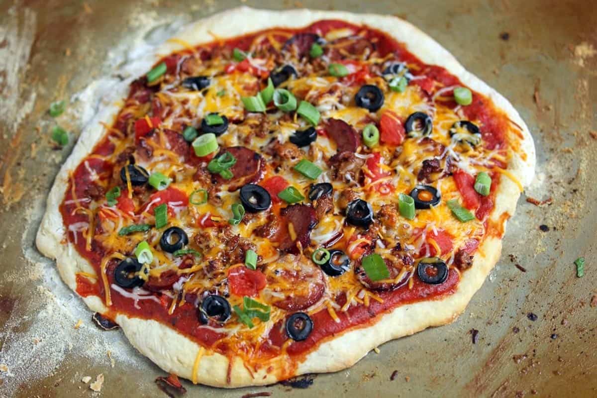 A chorizo mexican pizza on a pan ready to eat.