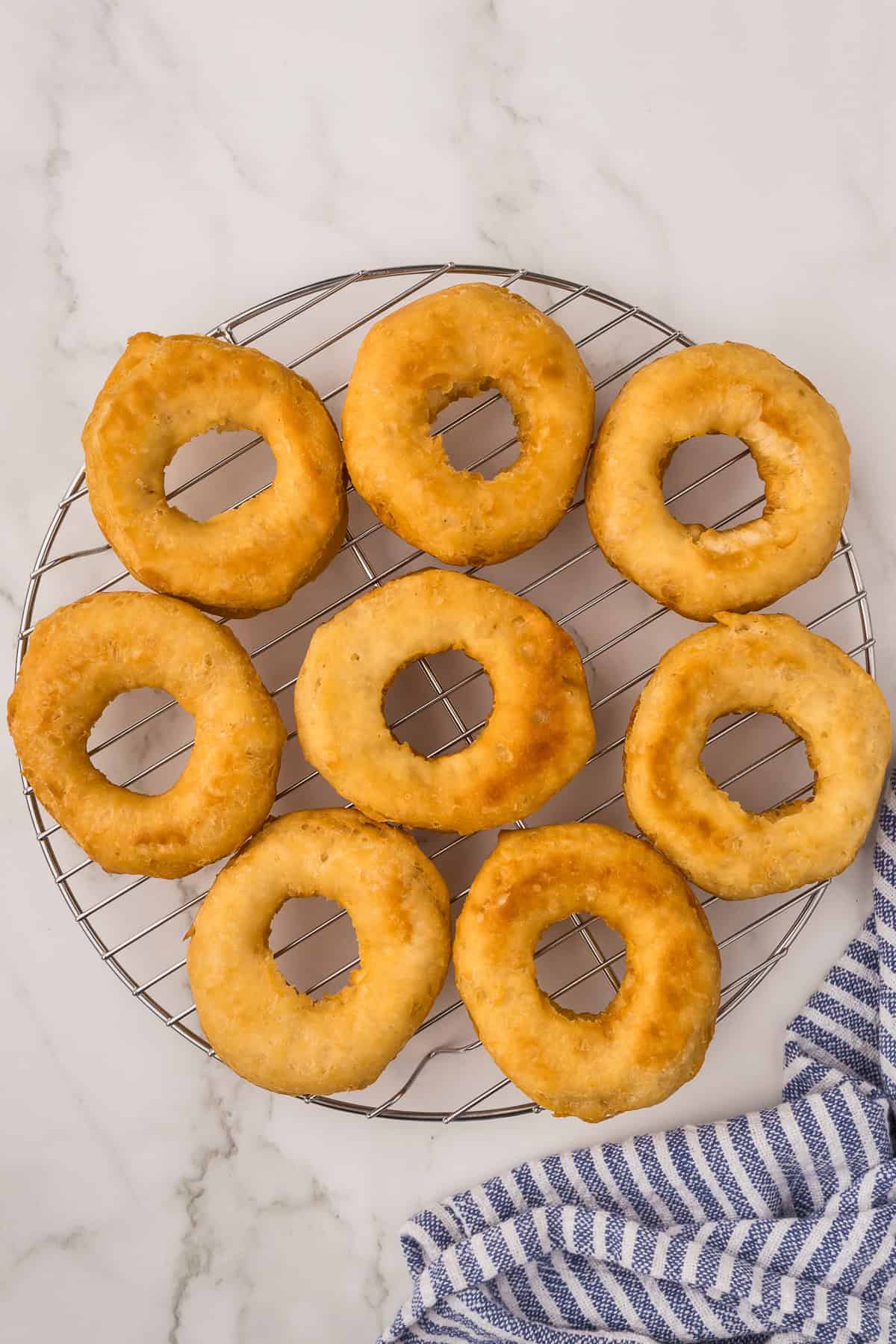 Golden fried doughnuts cooling on a wire rack