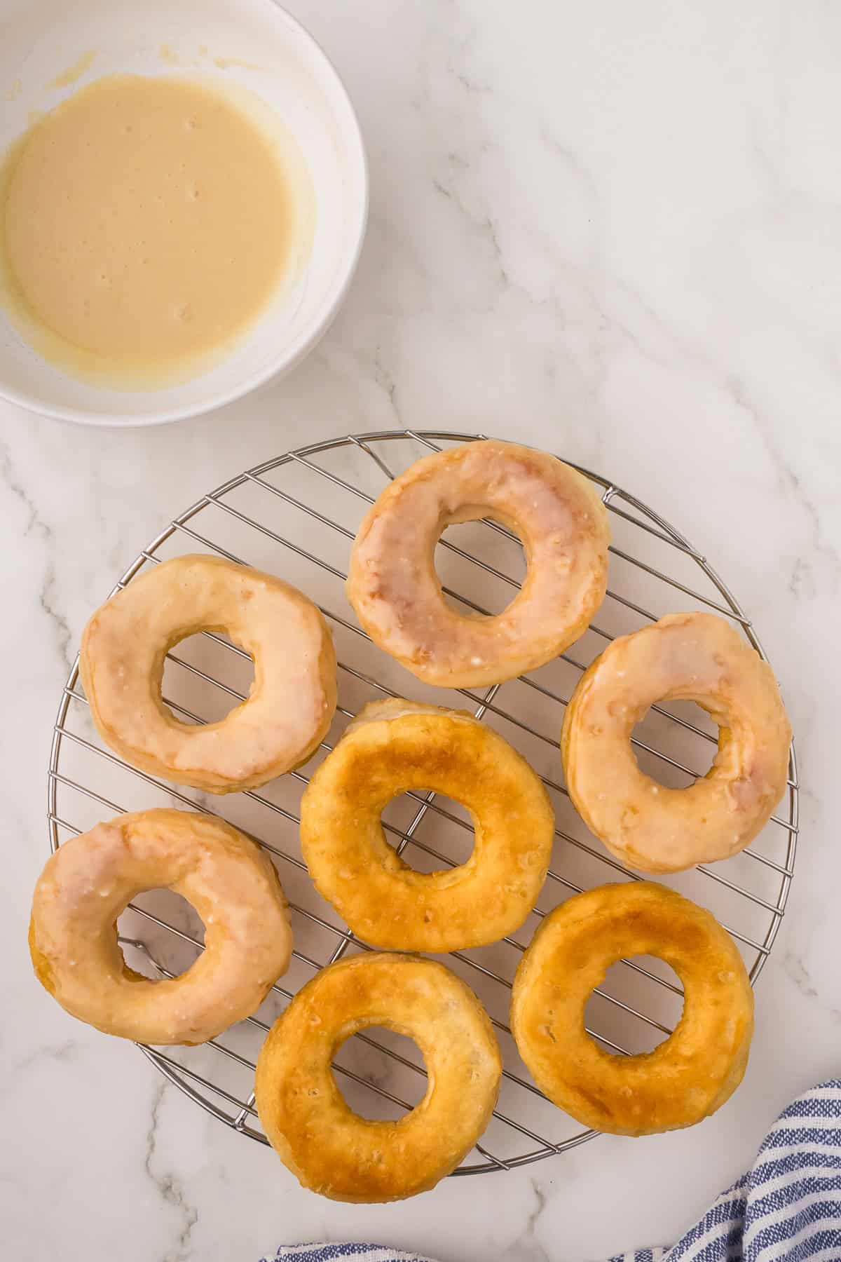 Several plain glazed doughnuts on a wired rack