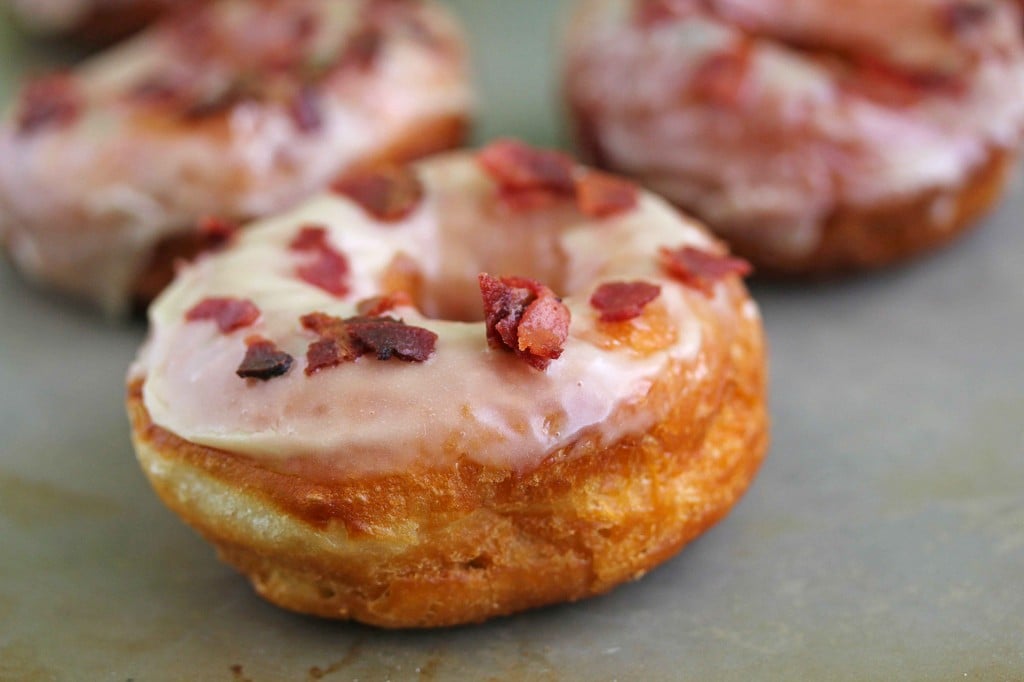 Maple bacon doughnuts with two more in the background