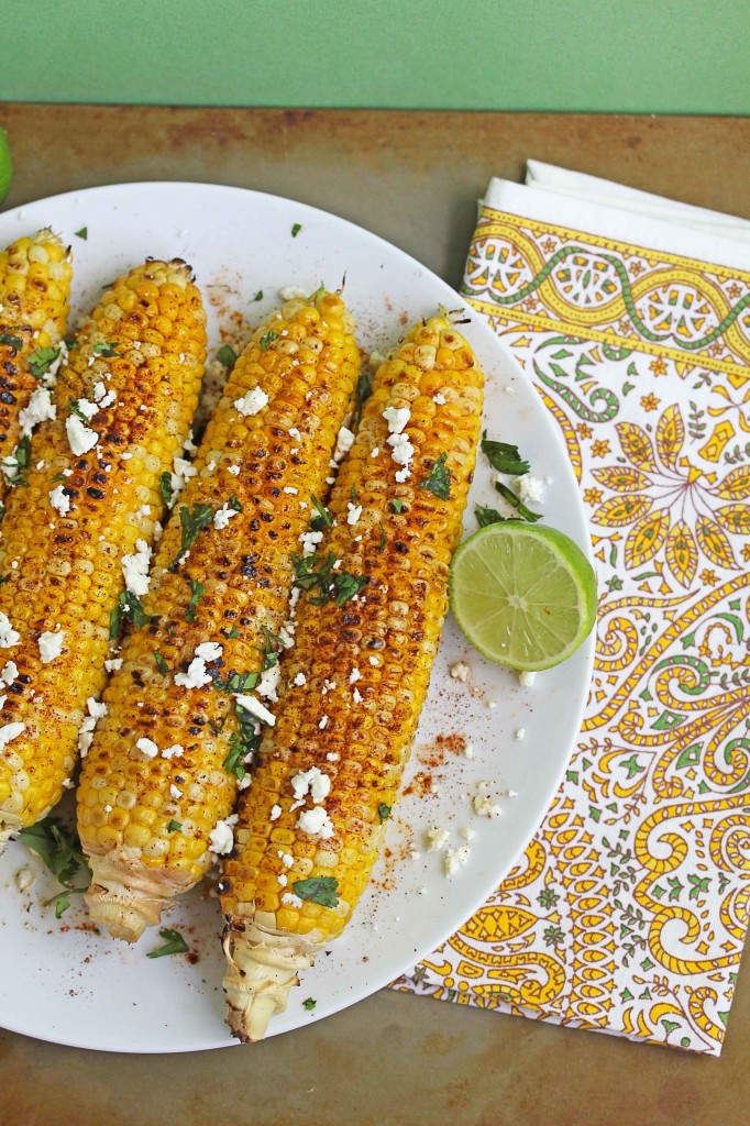 Overhead shot of Mexican grilled corn on a circular, white plate