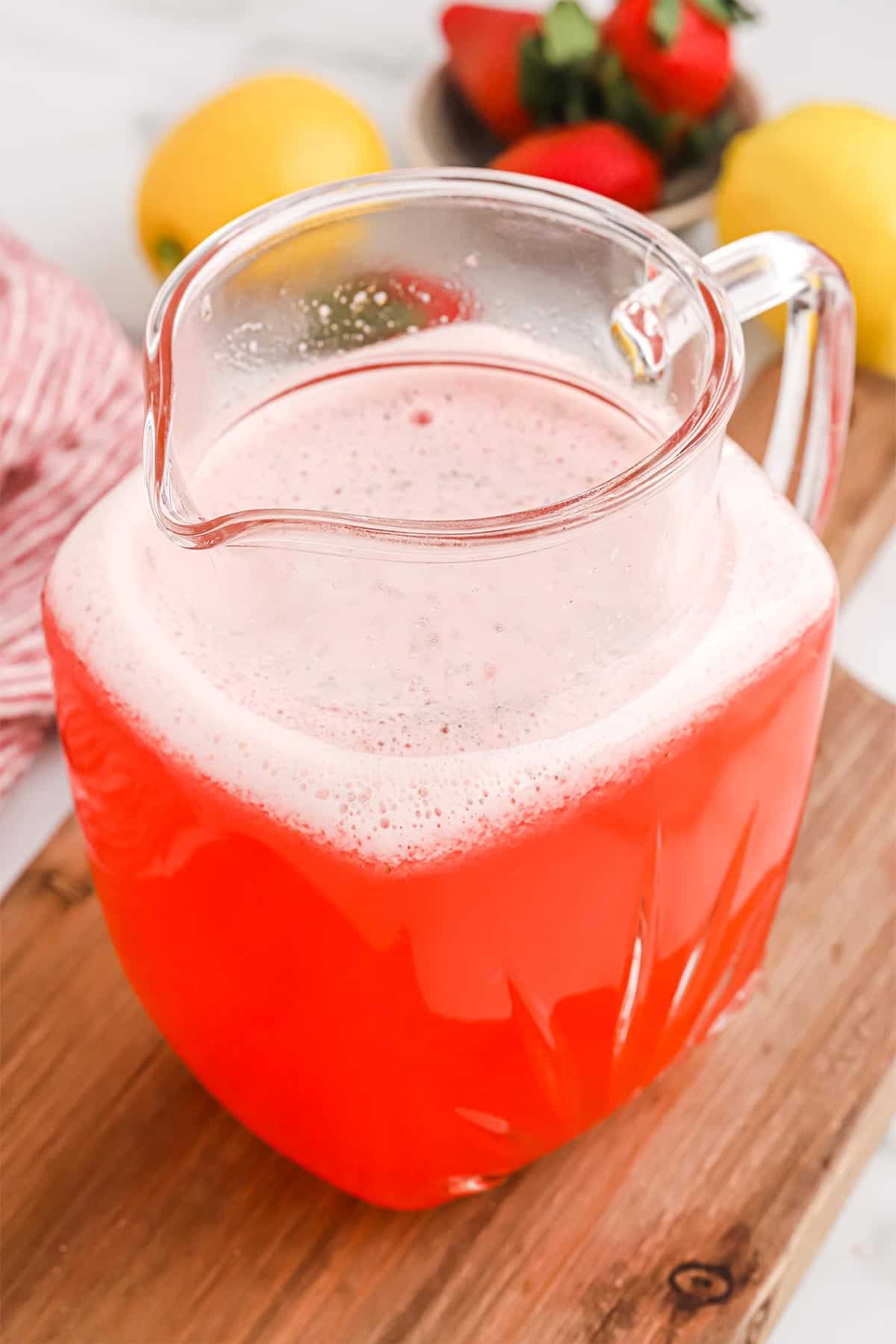 A pitcher of freshly made strawberry lemonade.