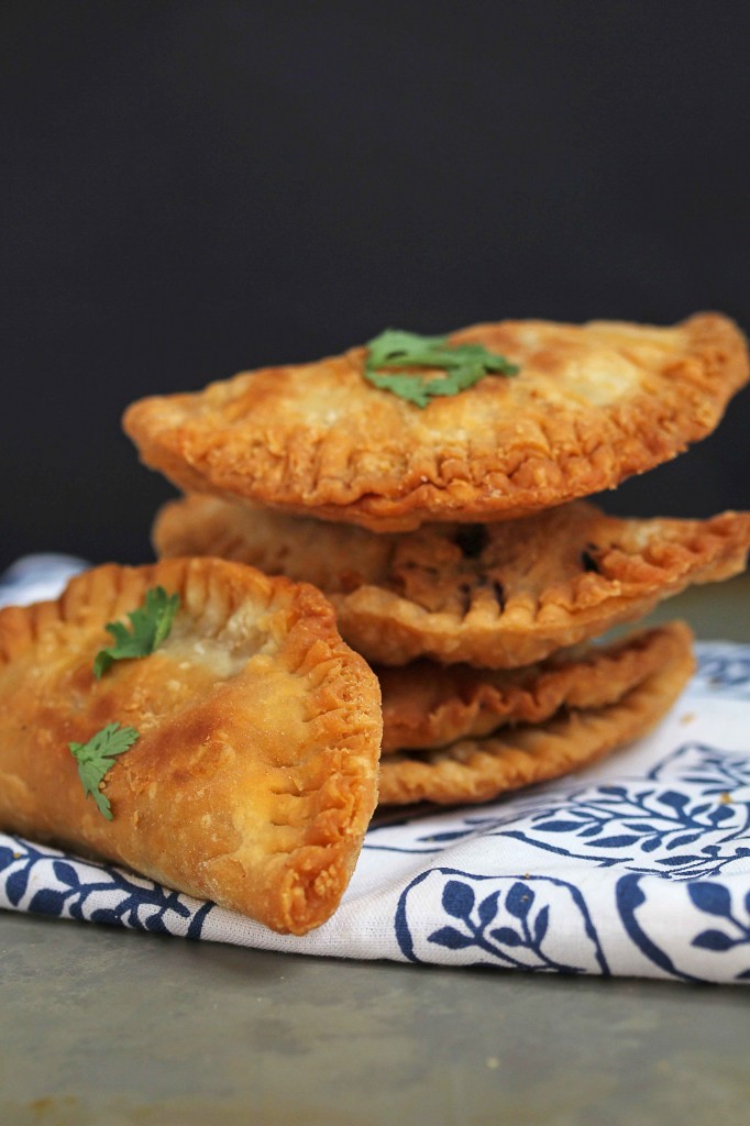 Close up of a stack of Ground Turkey Empanadas sitting on a white and blue cloth on a black background