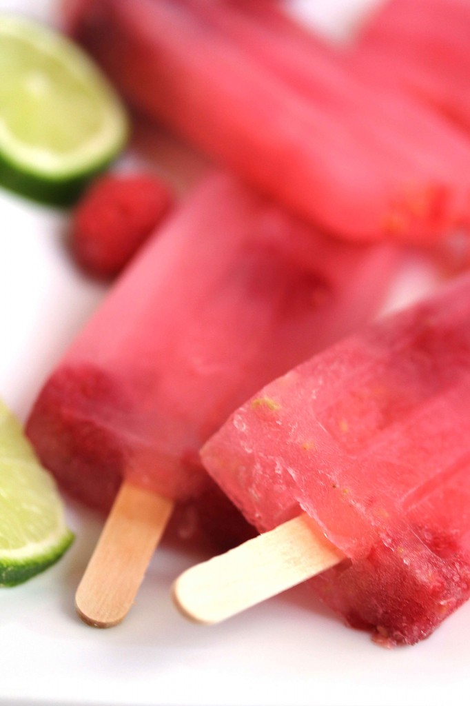 Close up of a couple of raspberry limeade popsicles with more in the background