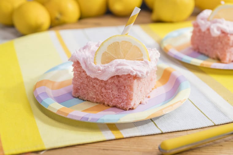 A delicious pink lemonade cake sitting on. colorful plate
