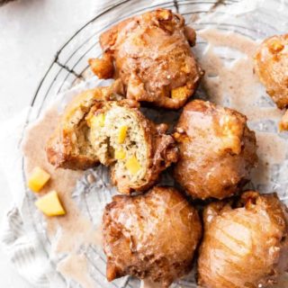 Overhead of bitten peach fritters against white background