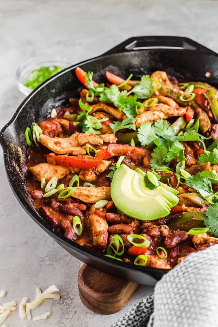 Close up of a black cast iron skillet full of fajita chili 