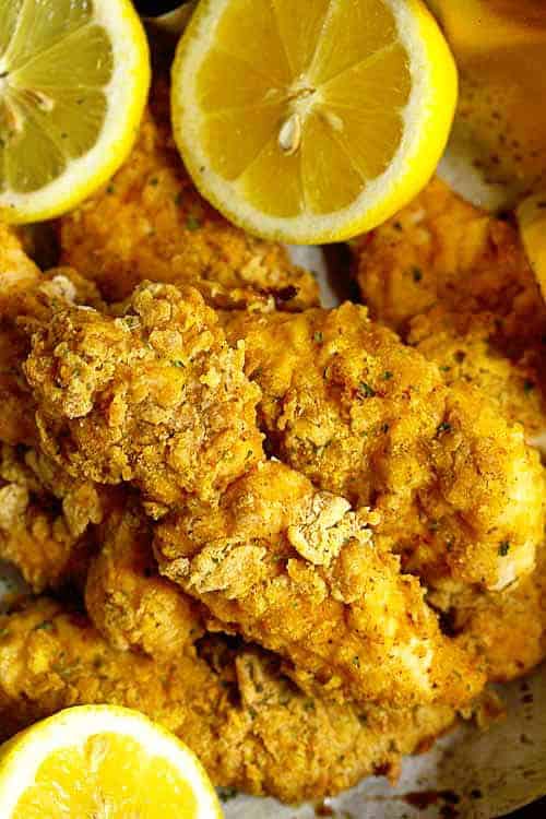 Close up of Chicken Tenders on parchment paper with lemons