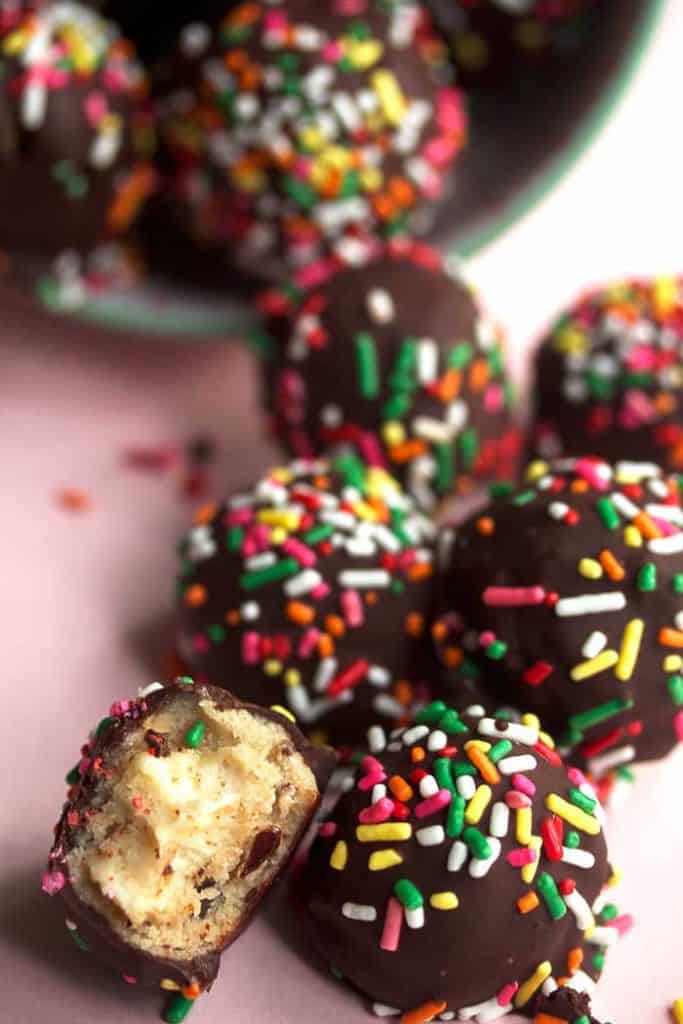 Close up of several cheesecake cookie dough truffles topped with sprinkles