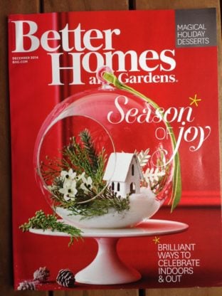 The cover of Better Homes & Gardens' Holiday issue with a Christmas ornament in front of a red door