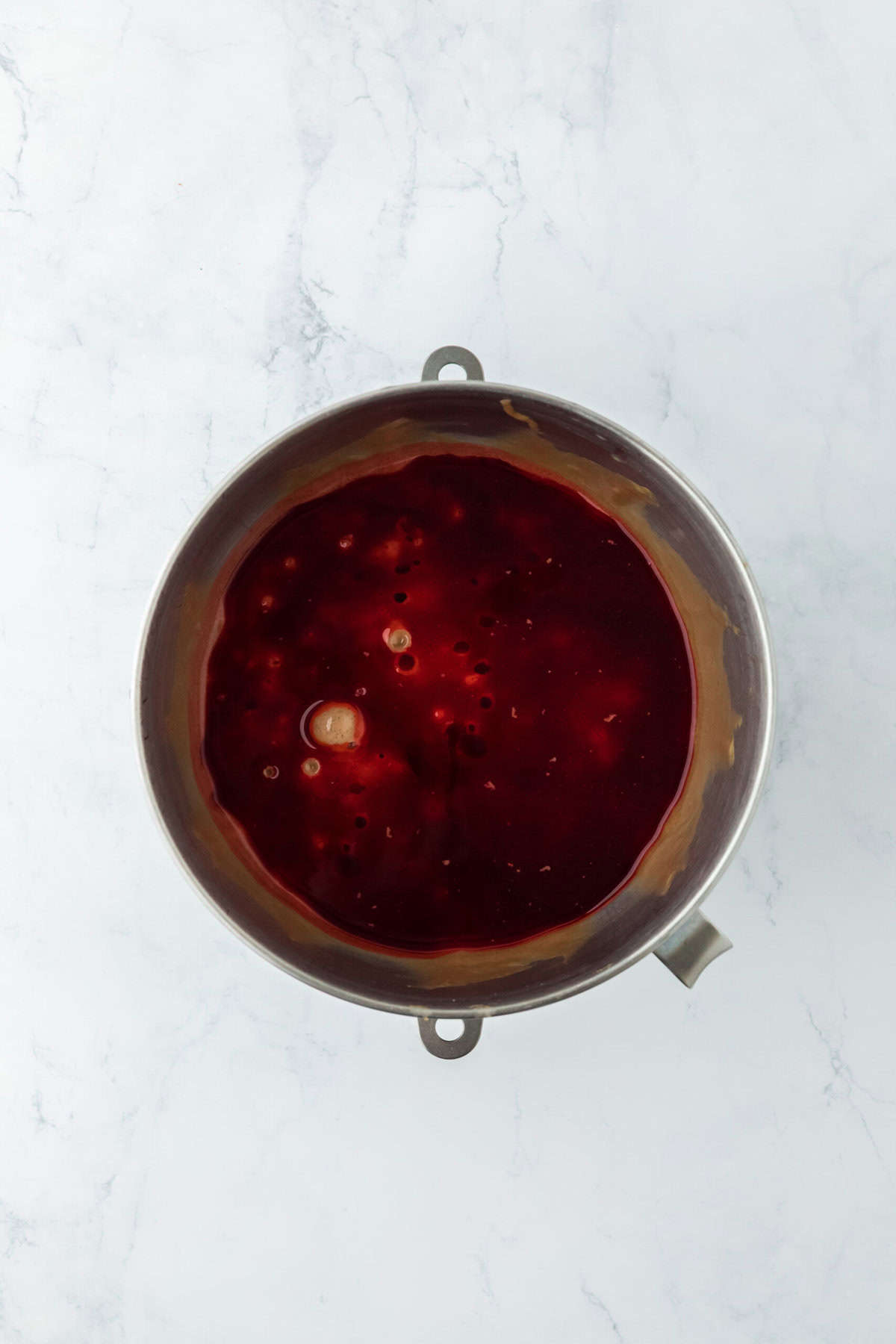 Red food coloring and coffee going into cake mix