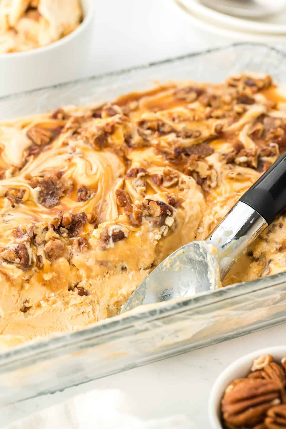 A close up of container with sweet potato ice cream recipe with scooper