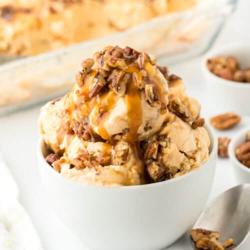 Sweet potato ice cream in a white bowl with carton of ice cream in white background