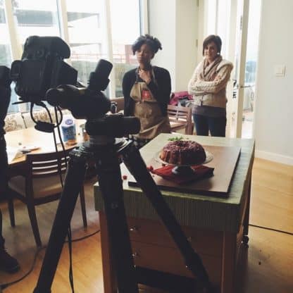 Two food bloggers stand in front of a video camera