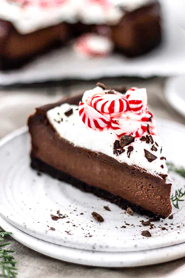 A clean slice of chocolate cheesecake on a white plate ready to serve