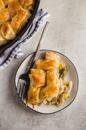 A plate of Easy Pot Pie recipe with Slow cooker chicken on plate next to homemade chicken pot pie skillet
