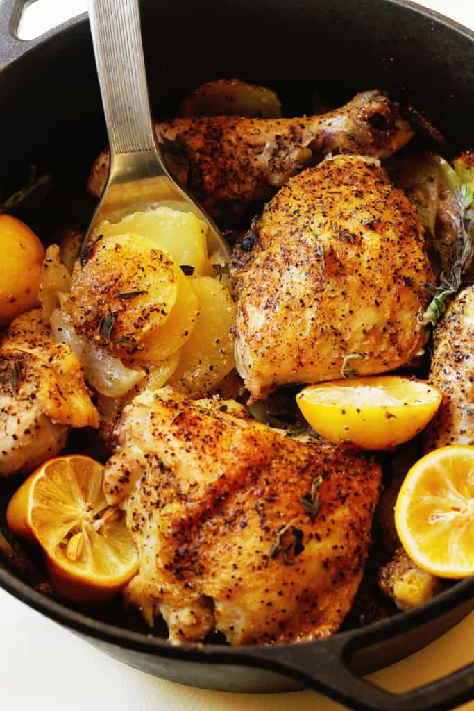 A close up of Lemon Roasted Chicken and Potatoes being served with potatoes being spooned