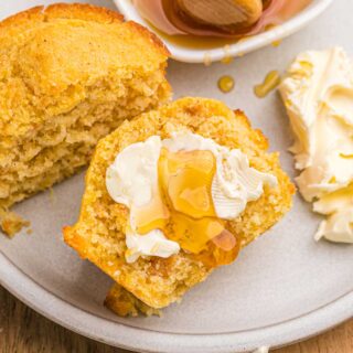 Sweet potato cornbread muffin split in half and topped with butter and honey.