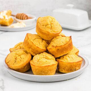 Pile of sweet potato cornbread muffins on a plate.