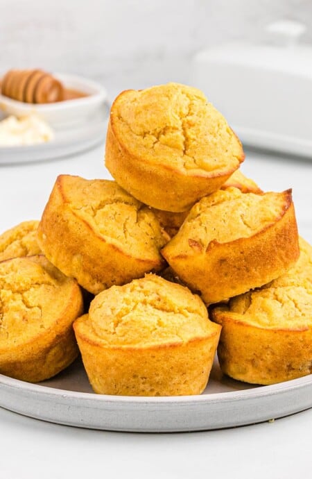 Pile of sweet potato cornbread muffins on a plate.