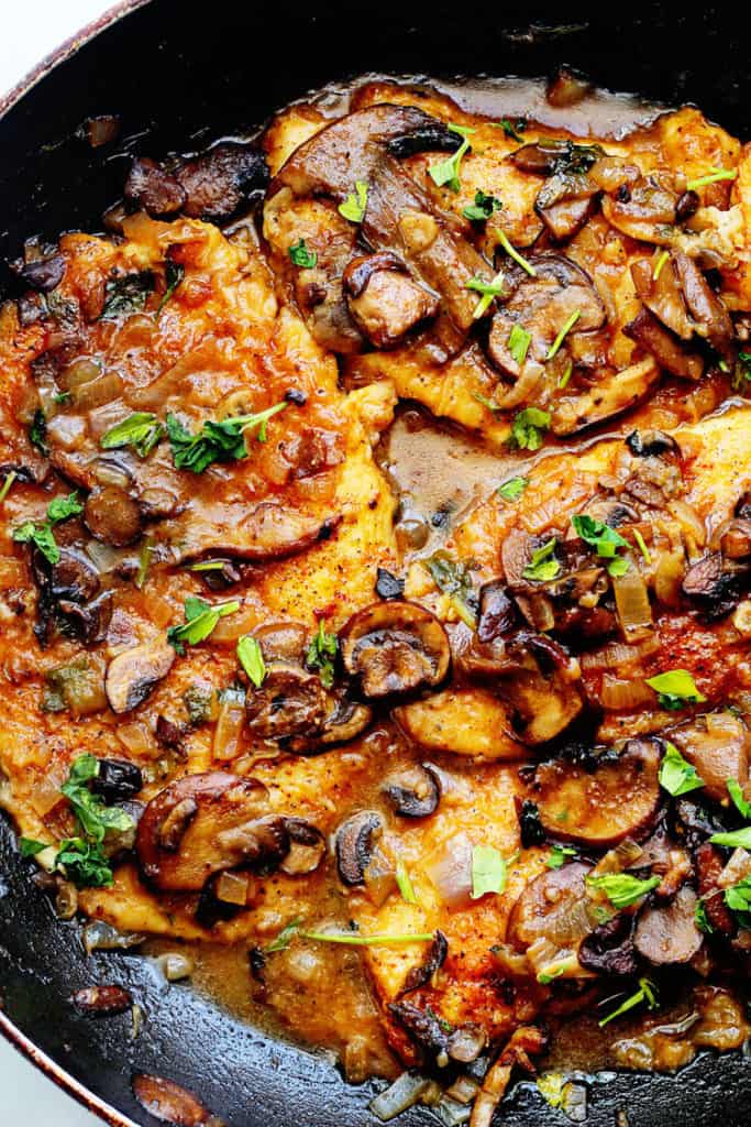 A overhead shot of a Chicken Marsala recipe in a skillet with mushrooms simmering away