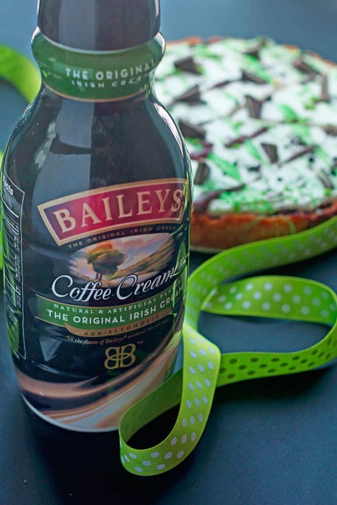 Close up of a bottle of Bailey's Original Irish Cream and a St. Patrick's Day Dessert Pizza in the background