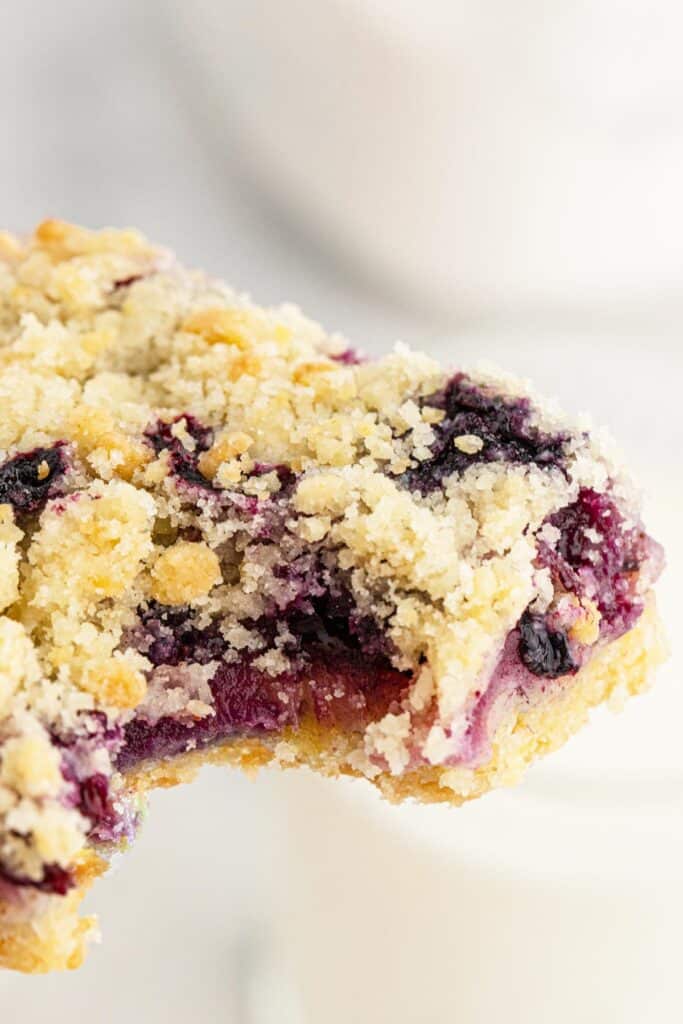 One blueberry crumble pie in a bar which has been eaten with blueberries