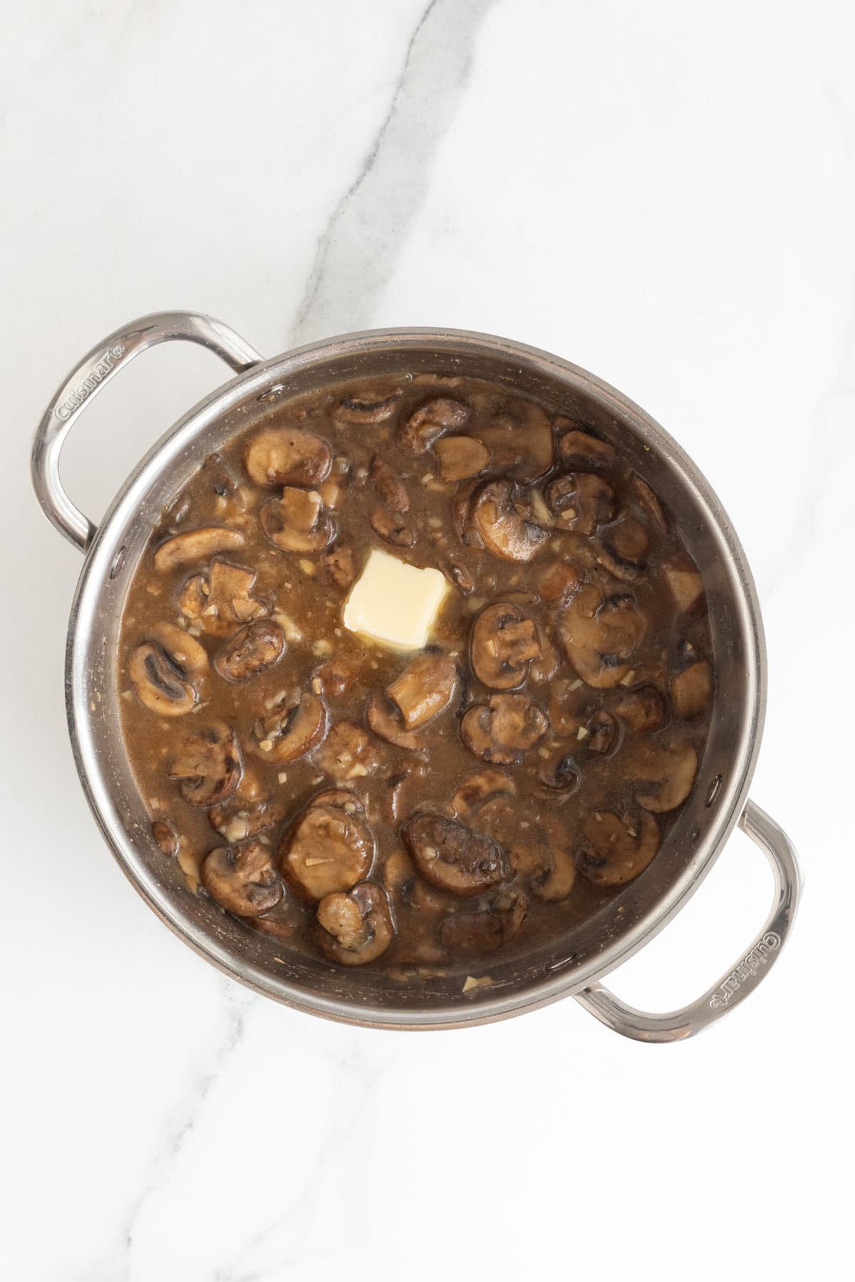 Butter added to marsala sauce cooking in skillet