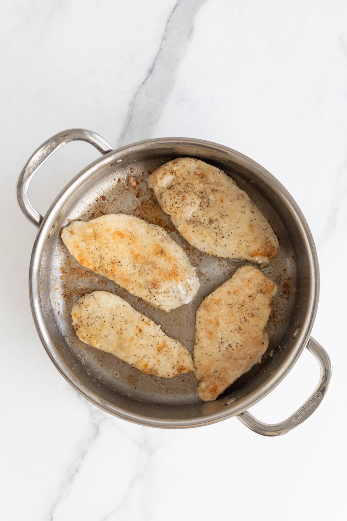 Seared chicken in an oiled skillet