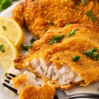Tender flaky oven fried fish being cut open